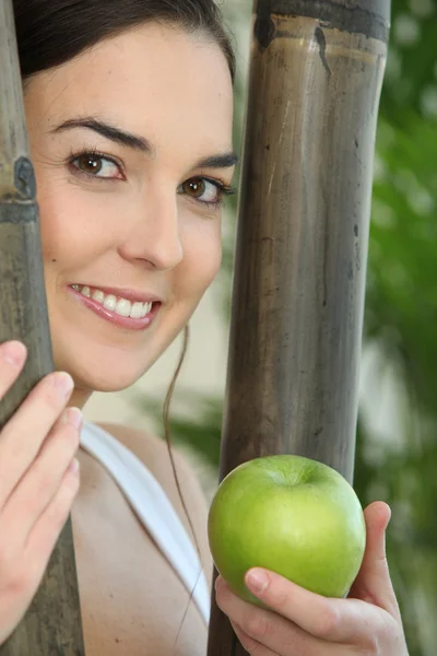 Ung kvinna som håller ett äpple — Stockfoto