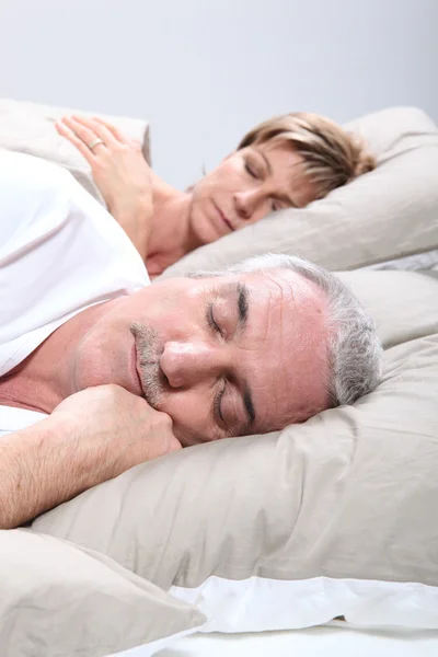 Äldre par i sängen sovande — Stockfoto