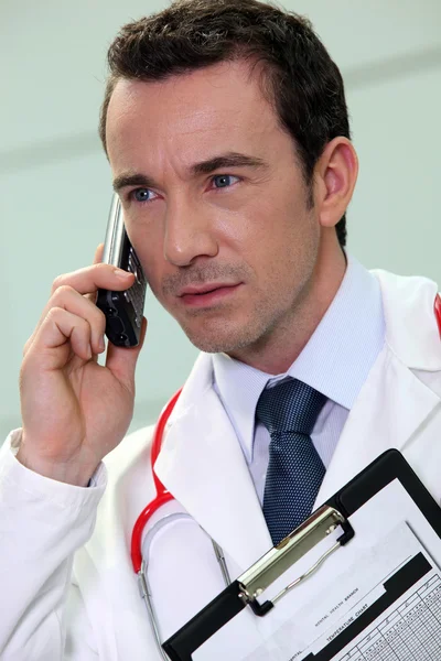 若い医者は彼の携帯電話で話しています。 — ストック写真
