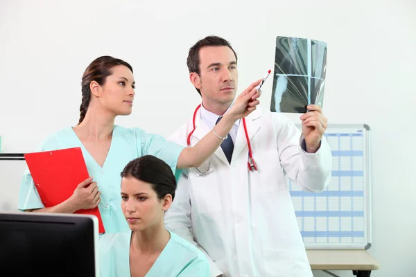 Equipo médico discutiendo una radiografía — Foto de Stock