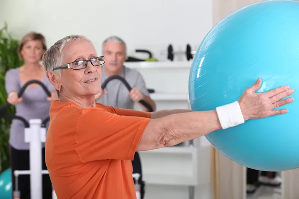 Mujer mayor levantando globo de fitness —  Fotos de Stock