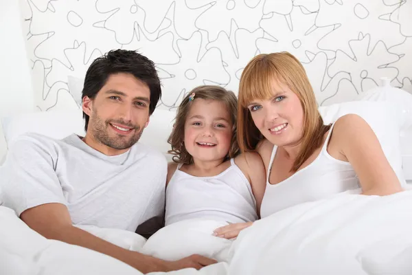 Família na cama juntos no domingo de manhã — Fotografia de Stock