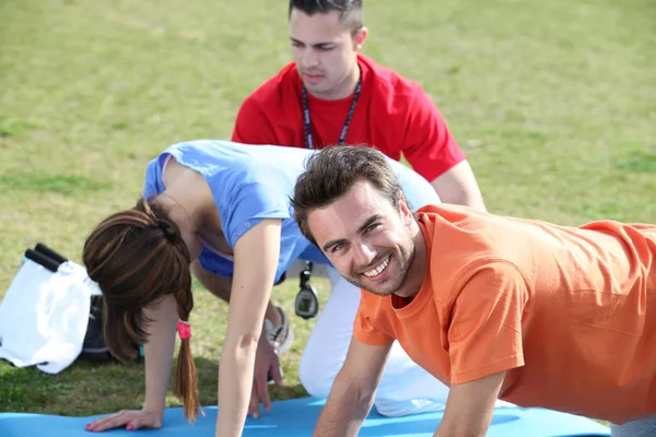 Young doing press ups in the park — Stock Photo, Image