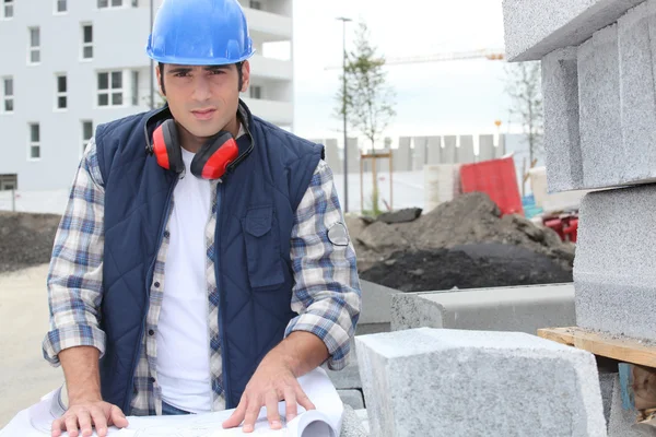 Trabajador de la construcción mirando sus planes — Foto de Stock