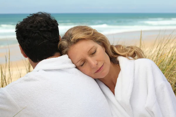 Couple in bathrobe at the beach — Stock Photo, Image