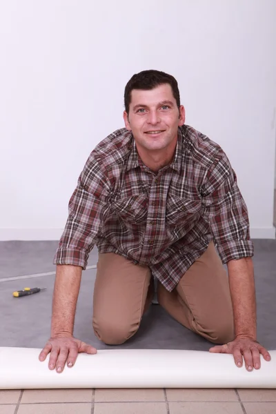 Hombre desenrollando alfombra — Foto de Stock