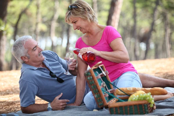 Medelålders par njuter picknick — Stockfoto