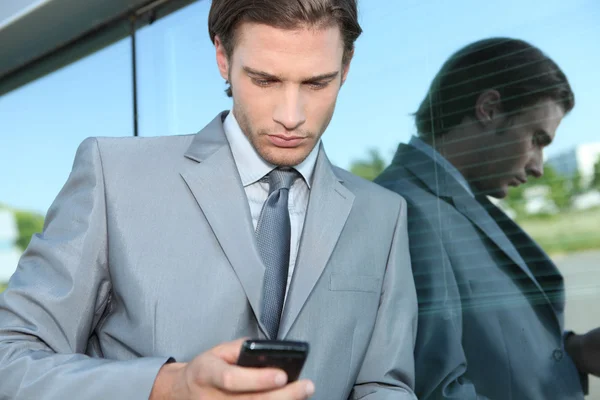 Jovem executivo usando um telefone celular — Fotografia de Stock