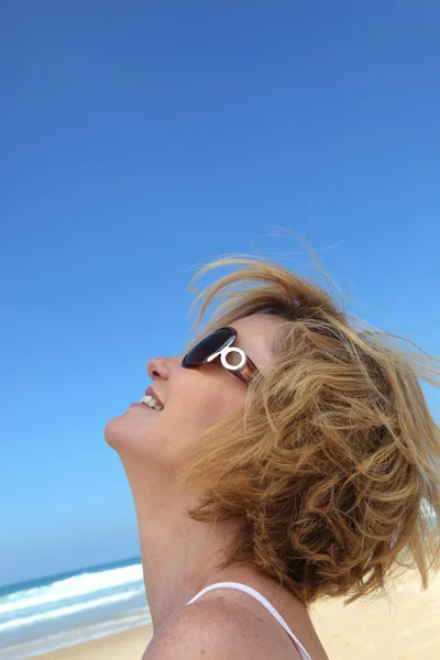 ビーチの背景を持つ女性の頭部のクローズ アップ — ストック写真