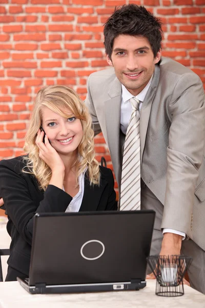 Smart couple with a laptop computer and cellphone — Stock Photo, Image