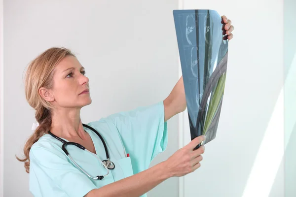 Krankenschwester schaut auf Röntgenbild — Stockfoto