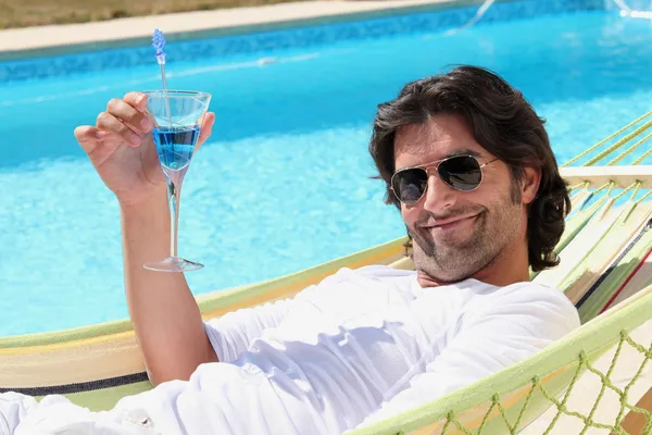 Homem relaxante junto à piscina — Fotografia de Stock