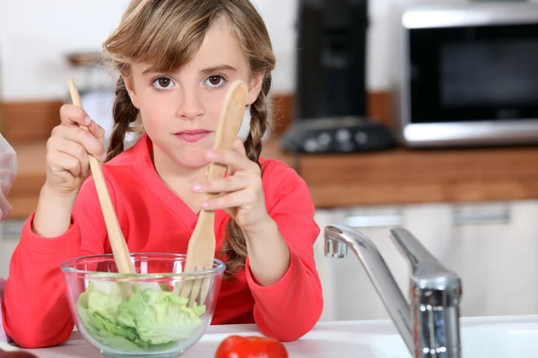 Mladá dívka vaření salát — Stock fotografie