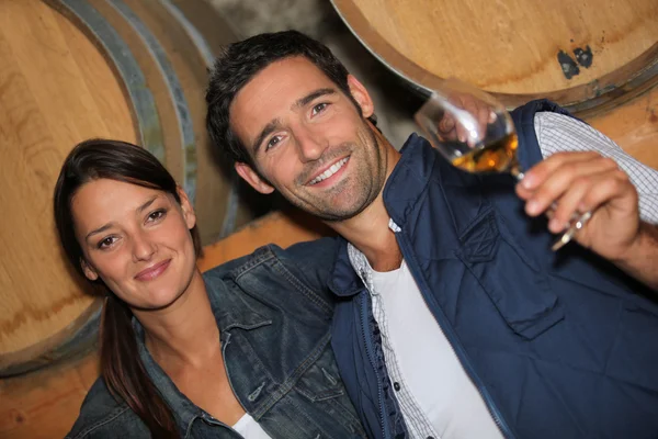 Молодая пара дегустирует вино в подвале — стоковое фото