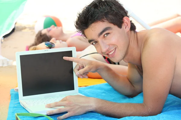 Genç adam onun laptop sahilde — Stok fotoğraf