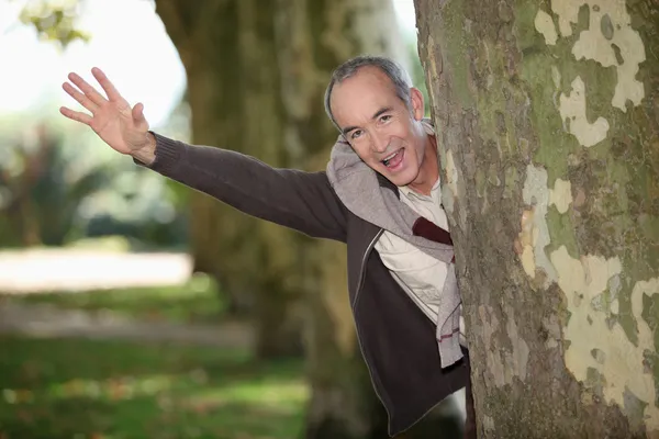 Mann springt hinter Baum — Stockfoto