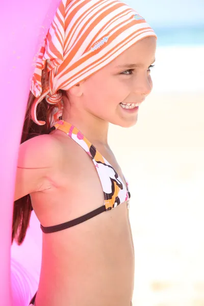 Bambina su una spiaggia con un anello di gomma — Foto Stock