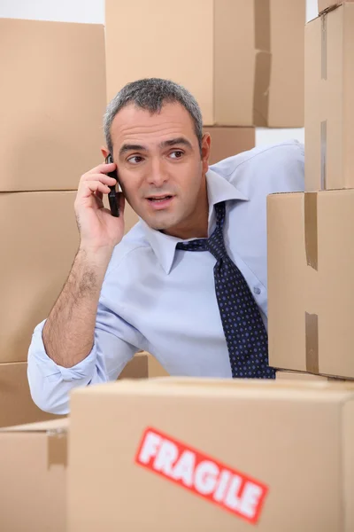 Cellphone user surrounded by boxes — Stock Photo, Image