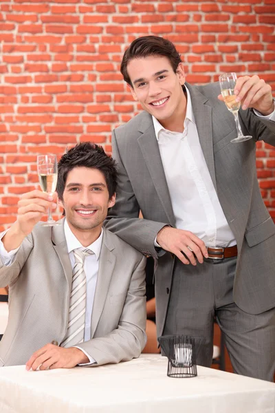 Junge Männer in Anzügen trinken in einer Weinbar — Stockfoto