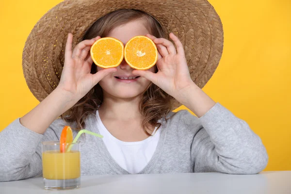 Девушка с апельсинами и соком — стоковое фото