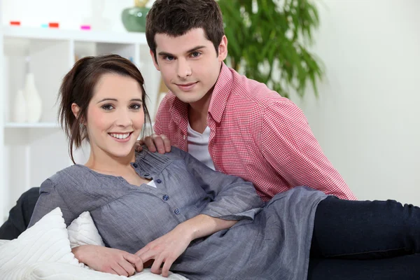 Νεαρό ζευγάρι για τον στον καναπέ — Φωτογραφία Αρχείου