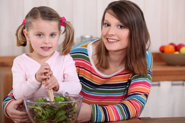 Mother and daughter preparing a salad. — Stock Photo, Image