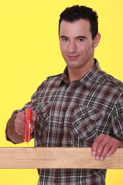 Muž řezání dřevěné prkno — Stock fotografie