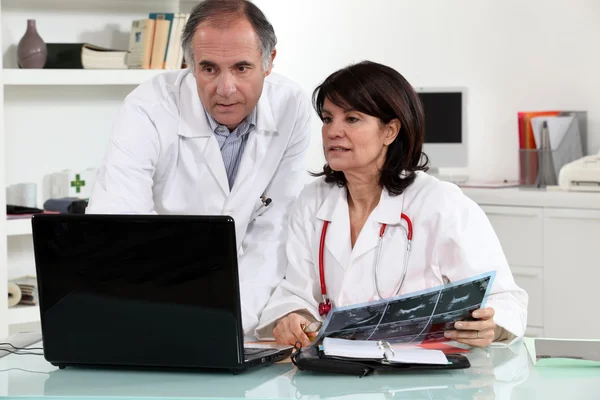Mannelijke en vrouwelijke artsen met laptop — Stockfoto
