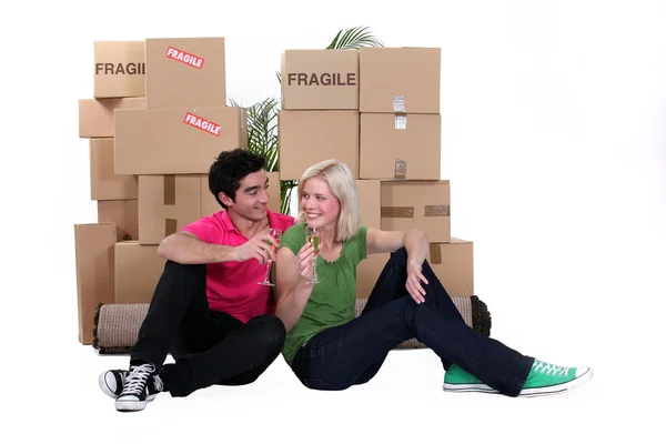 Unga par som flyttar in med champagne — Stockfoto
