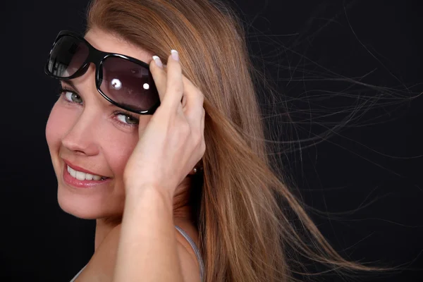 Donna che indossa occhiali da sole in una giornata ventilata — Foto Stock