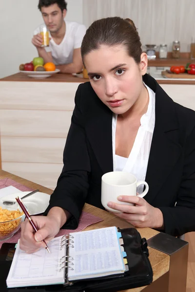 Νεαρός επιχειρηματίας τρώει το πρωινό της, και εξετάζοντας την Ατζέντα — Φωτογραφία Αρχείου