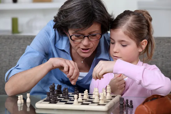 一位母亲教她的女儿如何玩象棋. — 图库照片