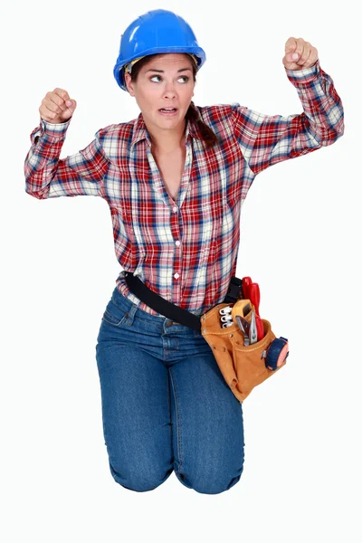 Craftswoman kneeling and clenching her fists — Stock Photo, Image