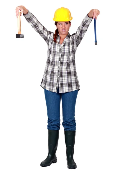 A female carpenter repulsed by her tools. — Stock Photo, Image
