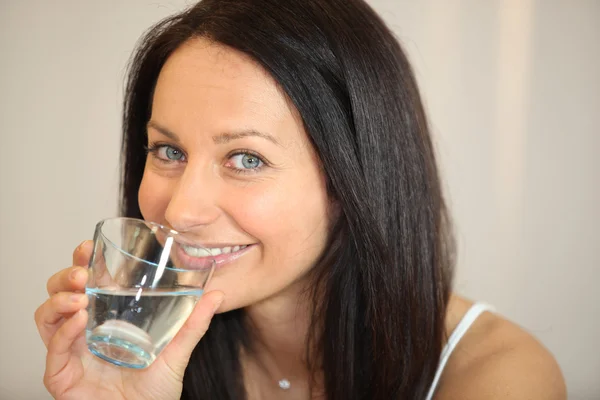 Morena bebendo um copo de água — Fotografia de Stock