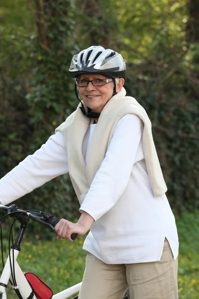 Elderly woman out riding her bike — Stock Photo, Image