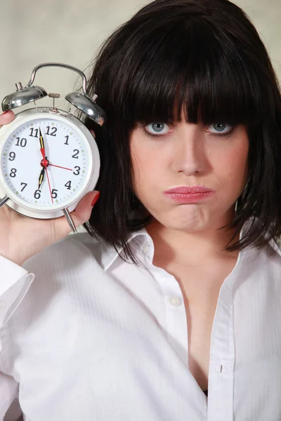 脾气暴躁的女人举行一个闹钟 — 图库照片