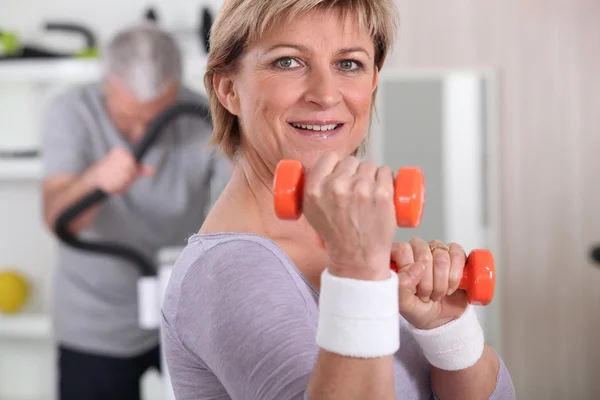 Mujer mayor haciendo ejercicios con una mancuerna — Foto de Stock