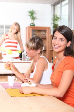 Young women having breakfast together clipart