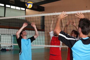 Volleyball players on indoor court clipart