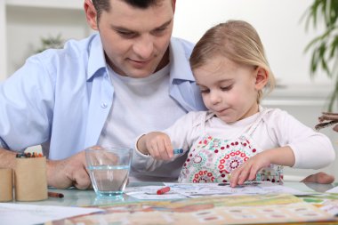 Young girl coloring with dad clipart