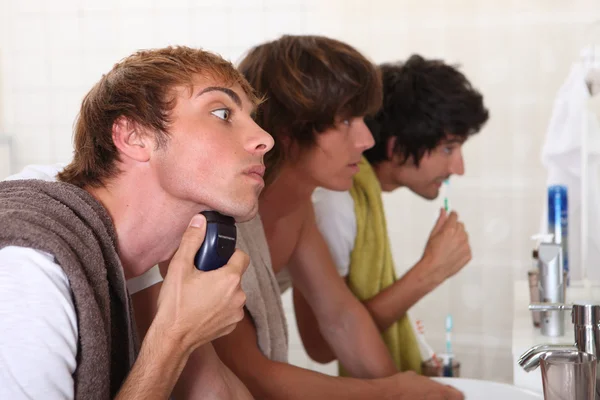 Троє молодих чоловіків у ванній готуються вийти — стокове фото