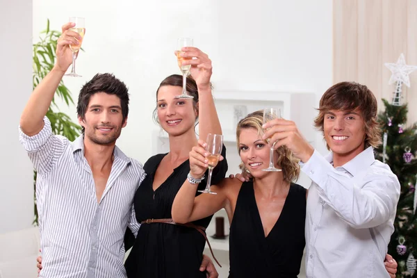 Two young couples drinking champagne at Christmas — Stock Photo, Image