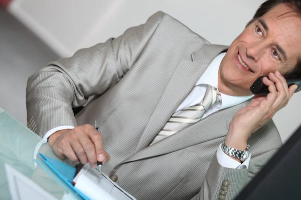 Empresário ao telefone sorrindo — Fotografia de Stock
