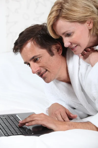 夫妇在笔记本电脑中的睡衣. — 图库照片
