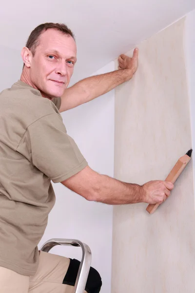 Homem pendurado papel de parede — Fotografia de Stock