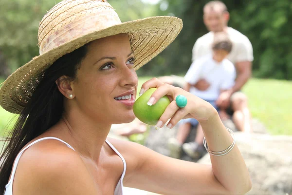 Giovane donna che mangia mela nel parco — Foto Stock