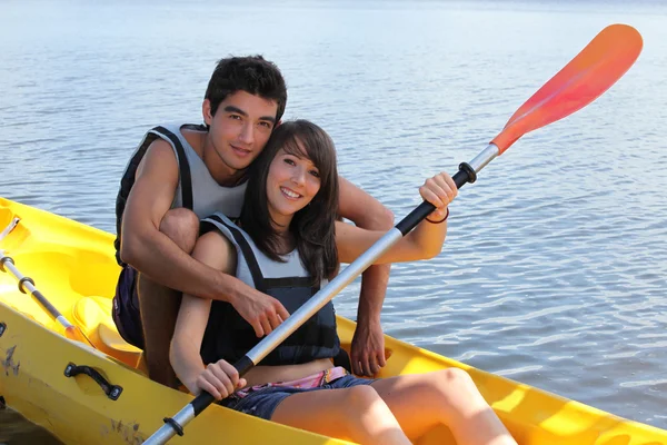 年轻的男人和女人在做独木舟在湖 — 图库照片