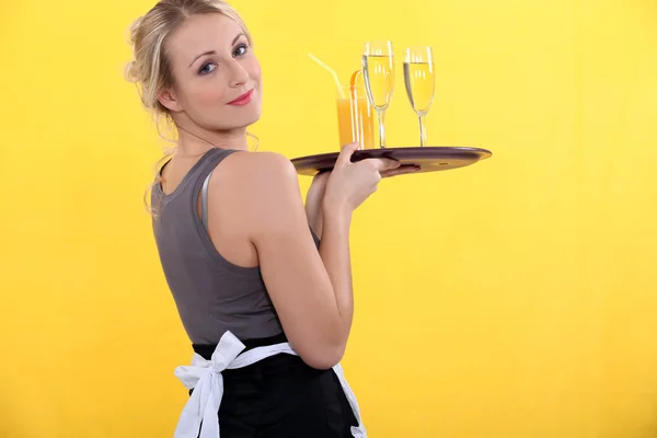 Blonde waitress bringing orange juice — Stock Photo, Image