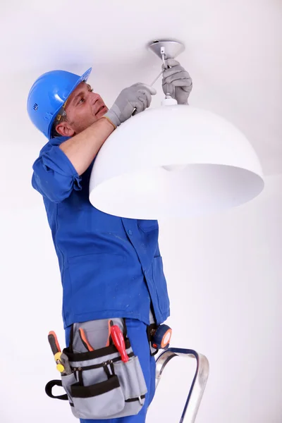 Électricien installant un plafonnier — Photo